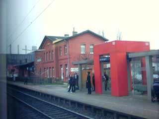 bahnsteig mit rotem unterstell gedöhns und gelangweilten figuren am rand