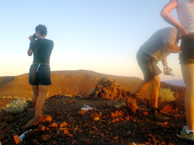 noch einmal namibia, wir waren einen berg hochgestiegen, um den sonnenuntergang anzuschauen; so weit unten im süden fällt die sonne fast vom himmel, in vierzig minuten ist es dunkel. auf dem foto sieht man dominique aus cape town, in die ich mich ein bißchen verknallt hatte, weil sie eine so warme, herzliche, zähe frau war (outdoor-ausdauersportlerinnen sind eine sehr interessante spezies, by the way), michi p., ein irrer, so vital, dass ich ihn sehr bestaunt und bewundert (und beneidet) habe, und anke, another very hinreißend human being.