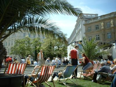 LIEGESTÜHLE AUF RASEN AM NEUGESTALTETEN WIENER KARLSPLATZ