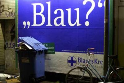 blaue tonne vor blauem plakat