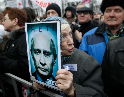 An elderly demonstrator holds a poster showing an edited photo of Prime Minister Vladimir Putin and signed &quot;2050. No&quot; during a mass rally to protest against alleged vote rigging in Russia's parliamentary elections in Moscow, Russia, Saturday, Dec. 10, 2011. 