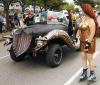 A slithery roadster with brass-bra'd Goth Girl escorts