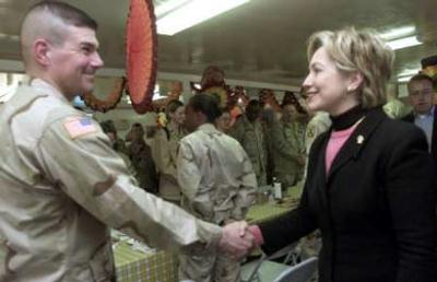 A US Army trooper shakes hands with Hillary Clinton (photo credit Reuters)