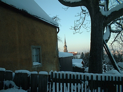 verschneites Bauernhaus in Possendorf mit Blick zur Kirche