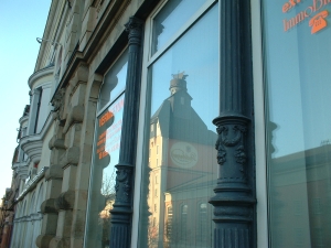 Spiegelung der Radeberger Brauerei im Schaufenster eines alten Ladens